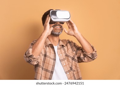 happy caucasian man Using VR headset and gesturing in beige colors. virtual reality, technology simulation concept. - Powered by Shutterstock