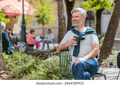 Happy Caucasian mature man enjoying morning coffee hot drink sitting on cafe chair. Relaxing, taking a break. Bearded guy on urban city center street, drinking coffee to go. Town lifestyles outside. - Powered by Shutterstock