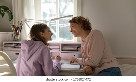 Happy Caucasian Mother And Teenage Daughter Sit At Desk In Bedroom Have Fun Studying Learning Together, Smiling Loving Mom Help Teenager Schoolgirl Child With School Homework, Education Concept