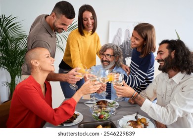 Happy Caucasian people toasting with white wine at a meal at home. Smiling family of diverse generations together around the table at festive event at weekend. Domestic life celebration  - Powered by Shutterstock