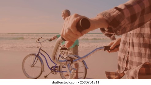 Happy caucasian senior couple riding bicycles together at the beach. Travel vacation retirement lifestyle concept - Powered by Shutterstock