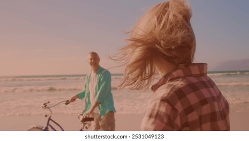 Happy caucasian senior couple riding bicycles together at the beach. Travel vacation retirement lifestyle concept - Powered by Shutterstock