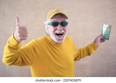 Happy Caucasian Senior Man Doesn't Believe His Eyes Holding Filled Winning Lottery Ticket And Celebrating Victory. Lucky Excited Smiling Mature Man Won A Jackpot.