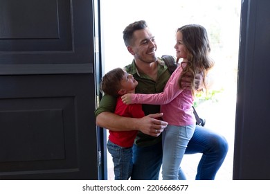 Happy Caucasian Siblings Welcoming Father Returning Home After Work. Family Time, Having Fun Together At Home.