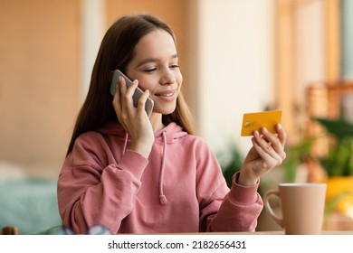 Happy Caucasian Teen Girl In Casual Outfit Making Order, Talking On Cellphone And Holding Credit Card, Spending Time At Home And Shopping Online, Copy Space