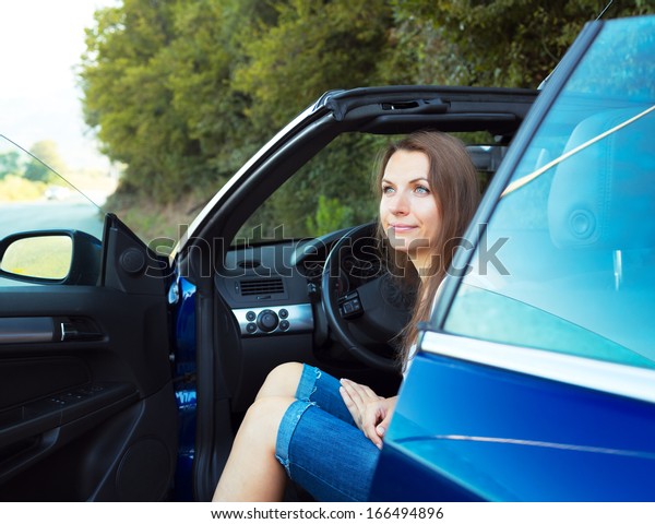 Happy caucasian woman\
in a cabriolet car