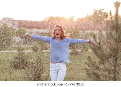 happy caucasian woman dancing under the summer rain. enjoying with drops 