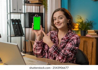 Happy Caucasian woman freelancer looking at camera and showing smartphone with green screen for new application. Businesswoman gesture thumbs up holding cellphone with chroma key mock up green screen. - Powered by Shutterstock