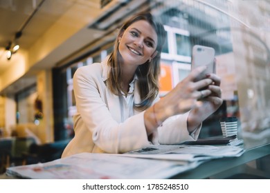 Happy Caucasian woman smiling at front camera while clicking selfie content pictures, cheerful hipster girl enjoying vlog streams using cellular device for shooting web video during pastime in cafe - Shutterstock ID 1785248510