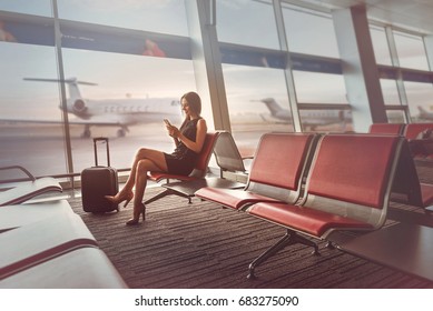 Happy Charming Lady Is Sitting On Bench At Airport