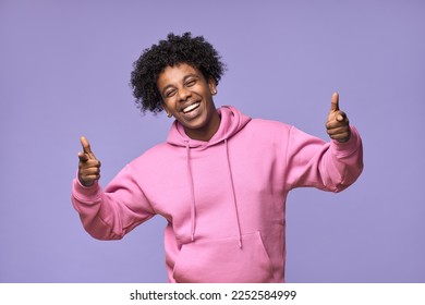 Happy cheerful African American teen guy wearing pink hoodie pointing fingers at camera. Smiling cool ethnic student model choosing you concept isolated on light purple violet background. - Powered by Shutterstock