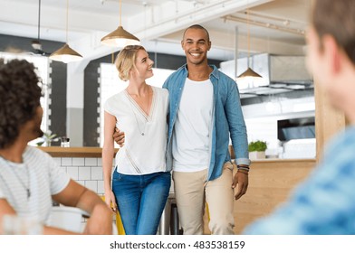 Happy Cheerful African Man Introducing His Beautiful Girlfriend To His Friends. Happy Friends Meeting Over Weekend To Enjoy. Happy Guys Wating Their Couple Friend At Cooffe Shop.