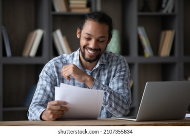 Happy Cheerful African Student Guy Reading Admission Letter From School, University, College, Receiving Paper Document, Smiling, Laughing. Millennial Businessman Getting Good Deal, Contract