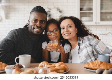 Happy cheerful african-american family, parents with preteen daughter girl having breakfast together, looking at camera. Parenthood and homeowners concept. Adoption and childcare - Powered by Shutterstock