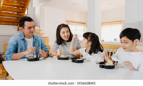Happy Cheerful Asian Family Having Lunch Eat Spaghetti Pasta In Plastic Container In Dining Room At Modern Home. Spending Time Together, Self-isolation, Social Distancing, Quarantine For Corona Virus.