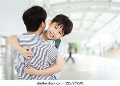 Happy cheerful Asian little boy running to his father at the railway or sky train station after his father returned from the traveling trip. Happy Asian family father and son concept. - Shutterstock ID 2257969591