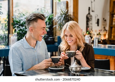 Happy cheerful caucasian middle-aged couple spouses drinking coffee talking enjoying romantic date together in cafe restaurant bar - Powered by Shutterstock