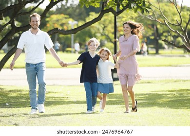 Happy - cheerful caucasian white family including father, mother, son, and daughter relaxing together at the public park in morning. Cheerful family with children going out for picnic at the park. - Powered by Shutterstock