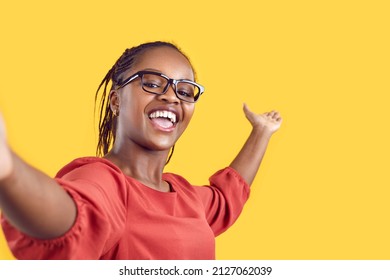 Happy Cheerful Confident Black Woman Takes Selfie, Films Tourist Sightseeing View Travel Vlog Or New Home Room Tour, Shares Positive Emotions, Inviting Welcoming Gesture On Empty Blank Mockup Backdrop