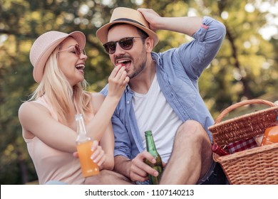 Happy Cheerful Couple Having A Picnic In The Park.