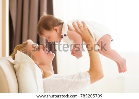 Happy cheerful family concept. Mother and three month baby kissing, laughing and hugging, close up portrait