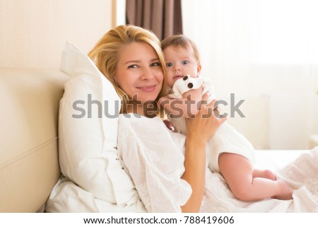 Happy cheerful family concept. Mother and three month baby kissing, laughing and hugging, close up portrait