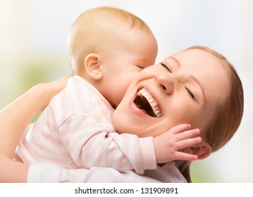 Happy Cheerful Family. Mother And Baby Kissing, Laughing And Hugging