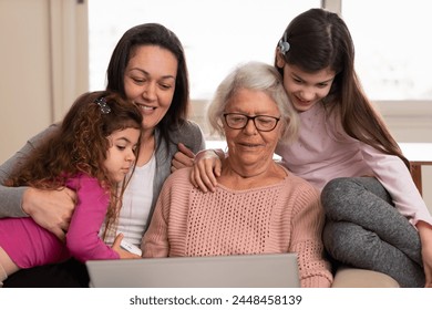 Happy cheerful female multigenerational family with laptop making an on-line purchase Inside the house in tv living room. E-commerce, online shopping, communication concept. - Powered by Shutterstock