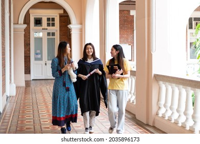 happy and cheerful Female university graduate students in academic dress chat with friends who came to congratulate on congregation day. corridor in the Renaissance style.