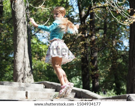 happy and cheerful girl vacation of 9 years with long blond hair that develops during the jump