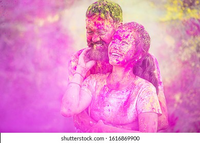 Happy cheerful  indian couple painted in colors celebrating holi festival outdoor.  - Powered by Shutterstock