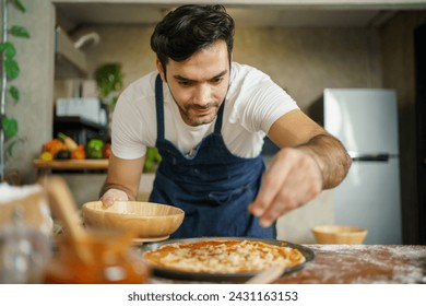Happy cheerful male and female Italian chef preparing a mixed flour for baking a homemade pizza. Chef sifting a wheat flour by using a sieve close up. - Powered by Shutterstock