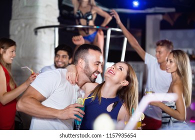 Happy cheerful  smiling man and woman dancing and hugging on party in the club