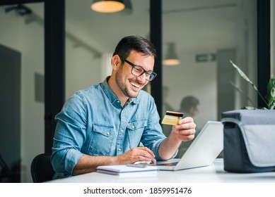 Happy cheerful smiling young adult man doing online shopping or e-shopping satisfied entrepreneur making online payment paying for service or goods self employed freelancer collecting fee paying happy