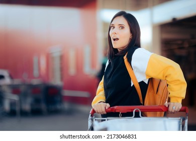 Happy Cheerful Supermarket Customer Pushing A Trolley. Joyful Millennial Girl Enjoying Her Shopping Experience At The Grocery Store
