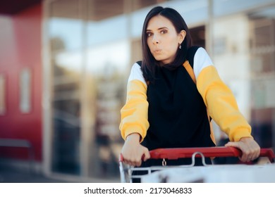 Happy Cheerful Supermarket Customer Pushing A Trolley. Joyful Millennial Girl Enjoying Her Shopping Experience At The Grocery Store
