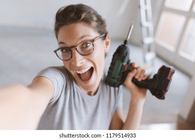 Happy Cheerful Woman Holding A Drill And Taking A Selfie, Home Renovation And Do It Yourself Concept