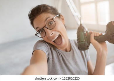 Happy Cheerful Woman Holding A Drill And Taking A Selfie, Home Renovation And Do It Yourself Concept