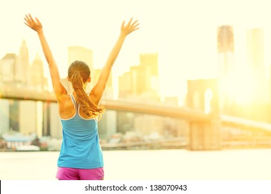 Happy Cheering Woman In New York City Enjoying View And Sun On Brooklyn Bridge. Fit Female Fitness Runner Joyful And Excited After Running.