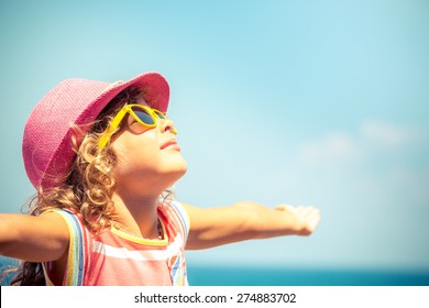 Happy child against blue sky background. Summer vacation concept - Powered by Shutterstock