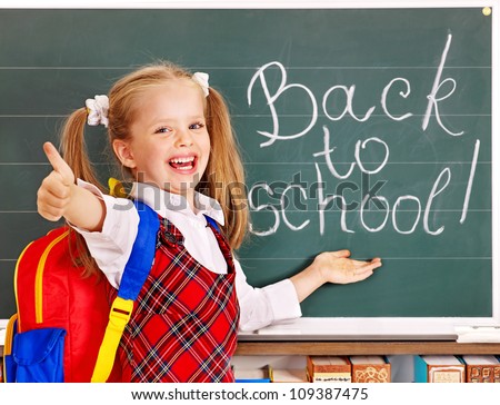 Happy child with backpack holding book. Isolated.