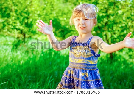 happy child blowing bubbles on nature in pairs