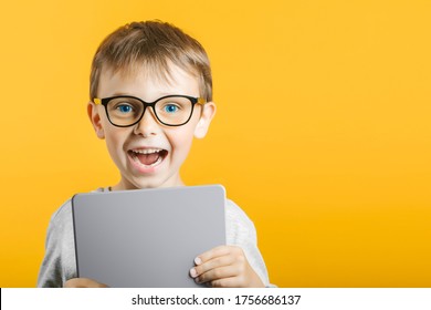 Happy child boy  holding a tablet ipade for your information on the blue background 