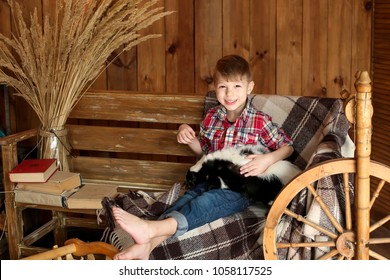 Happy Child, Boy Stroking A Black And White Skunk In A Photo Studio On A Wooden Background