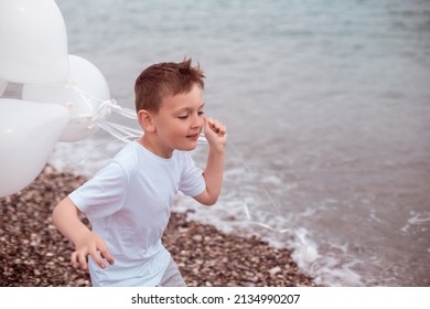 Happy Child Boy in White Dress with White Balloons