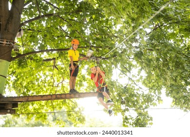 Happy child climbing in the trees. Rope park. Climber child. Early childhood development. Roping park. Balance beam and rope bridges. Rope park - climbing center - Powered by Shutterstock