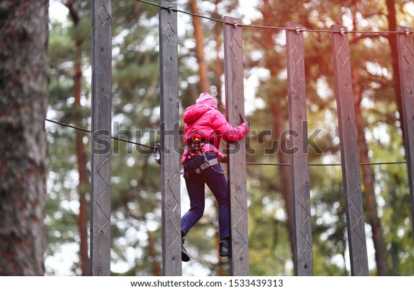 Happy child climbing in the trees. Rope park.
Adventure climbing. Rope
bridges.