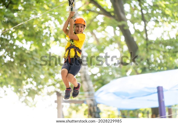 Happy child climbing in the
trees. Rope park. Climber child. Early childhood development.
Roping park. Balance beam and rope bridges. Rope park - climbing
center