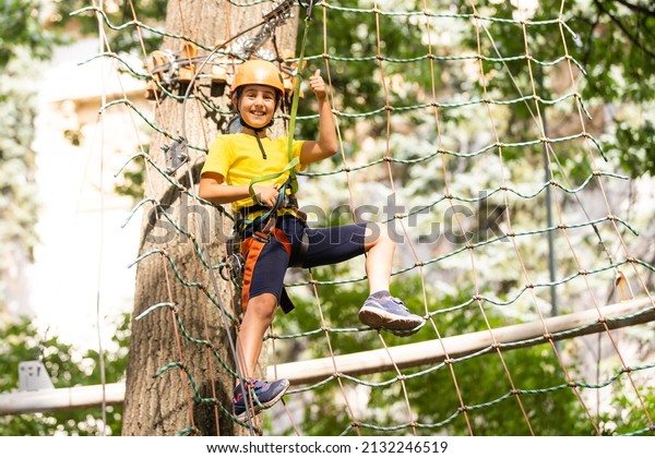 Happy child climbing in the
trees. Rope park. Climber child. Early childhood development.
Roping park. Balance beam and rope bridges. Rope park - climbing
center