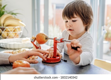 Happy Child Cooking With Mother Slicing And Peeling Aplle Using Apple Peeler Corer Slicer Machine. Children Cooking Charlotte Or Apple Pie At Modern Kitchen At Home Together. 